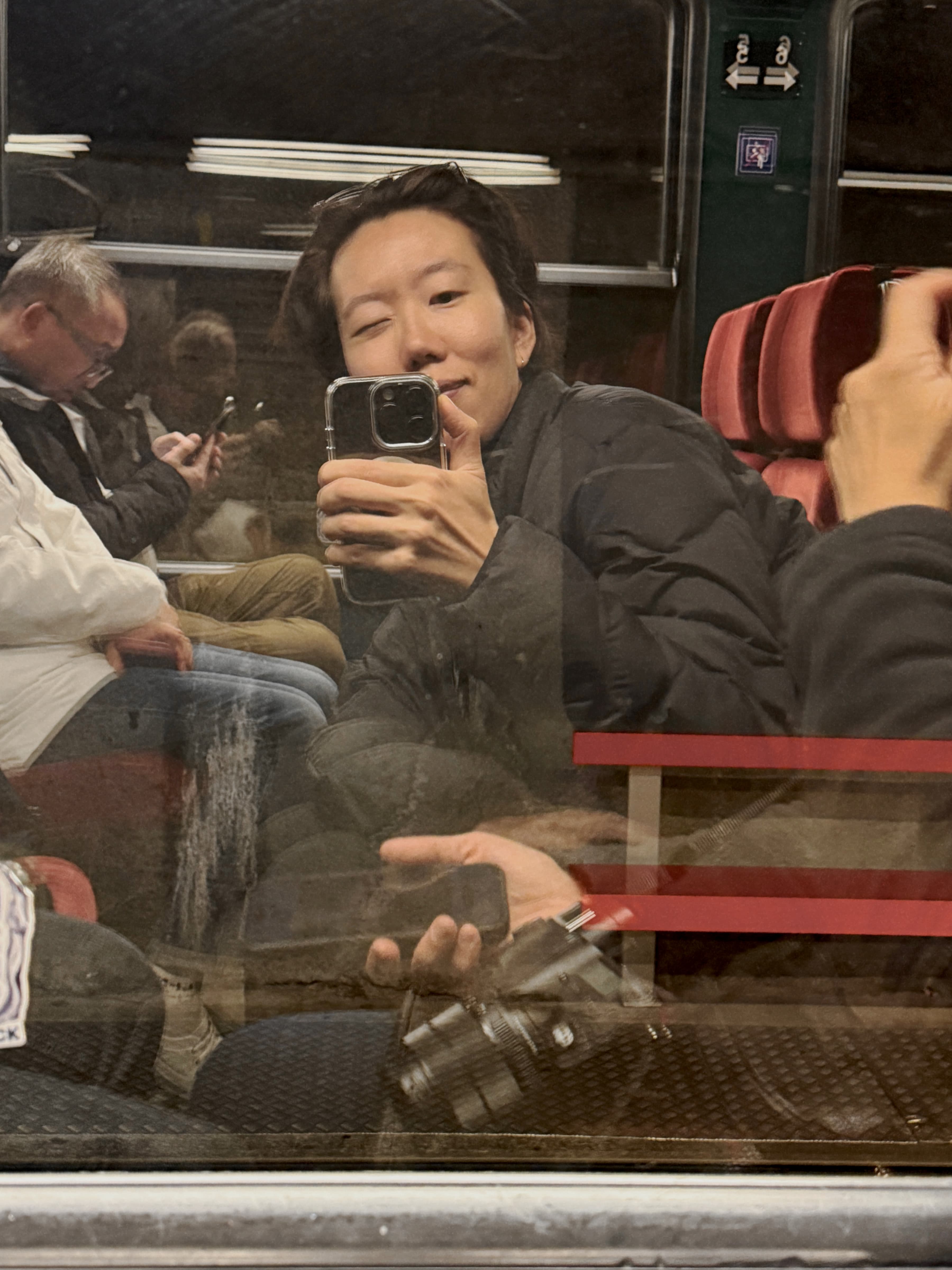 Minrey taking a mirror photo on a train.